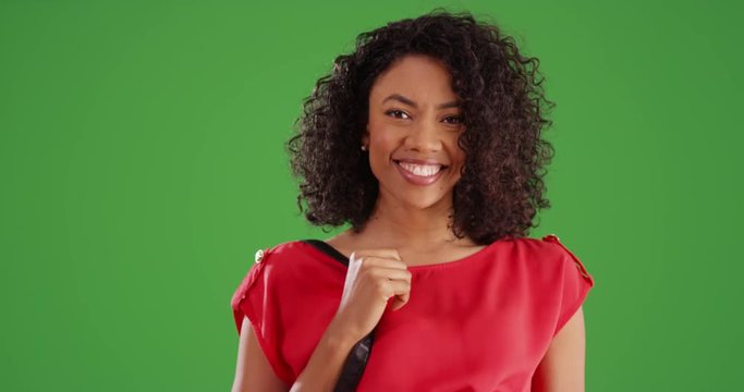 Beautiful Black woman running on and off screen and waving to camera on greenscreen background. Happy and playful young woman smiling and laughing on green backdrop for compositing or keying. 4k