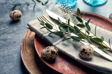 Beautiful festive Easter table setting with quail eggs, closeup
