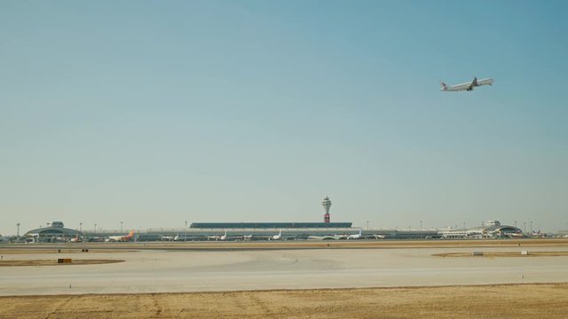 Passenger plane fly up over take-off runway from airport.