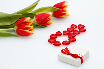 Card on March 8 - International Women's Day: Three red tulips present with a bow and number 