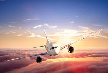 Naklejka premium Samolotowy odrzutowiec lata nad chmury w pięknym zmierzchu