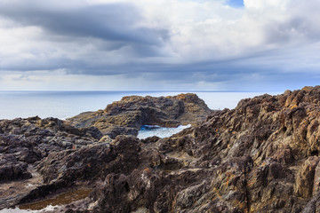 Headland and cliff face showing contact of Kiama Sandstone and Bumbo Latite with rock platform, Unusual coastal rock formations at kiama, New South Wales, Australia.