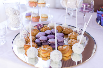 French macaroons cookies. Candy bar. A lot of sweets at the wedding banquet. Focus on the lilac macaroons 