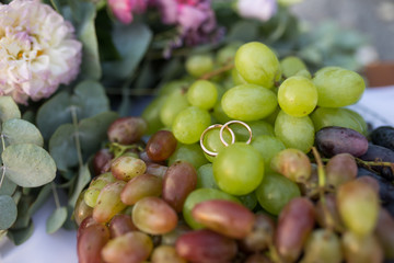 Gold wedding rings lie on the grape. Wedding