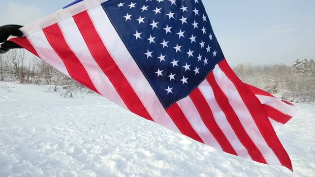USA flag waving in the wind, highly detailed fabric texture. US flag on ski slope winter day.