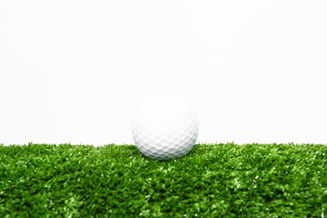 The golf ball is on the green lawn.