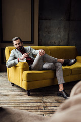 fashionable man with cigar and ashtray looking at camera