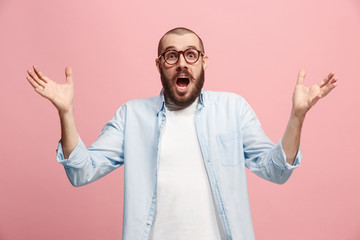 The young attractive man looking suprised isolated on pink