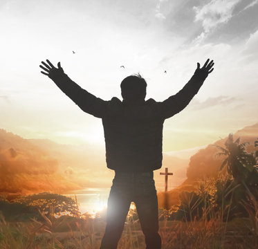 soft focus and Silhouettes of man raise hand up worship God against blurred sunset sky