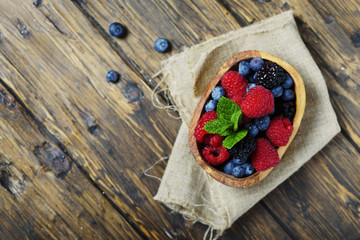 Mix of summer berries and mint on the wooden table