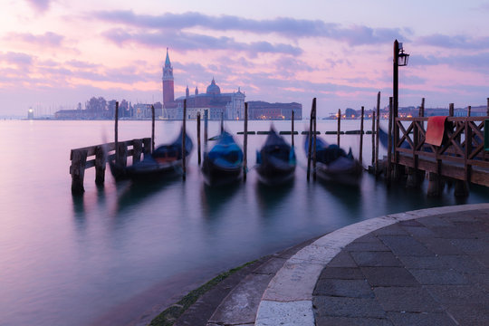 Venice classic sunrise view with gondolas on the waves