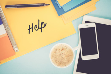 Notepad on workplace table and written HELP concept