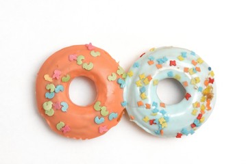 Two donuts stuck to each other. Orange color and mint color