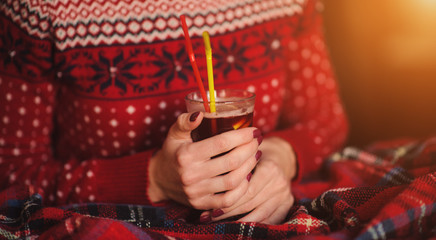 Cup with mulled wine in the hands of a girl