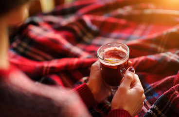 Cup with mulled wine in the hands of a girl