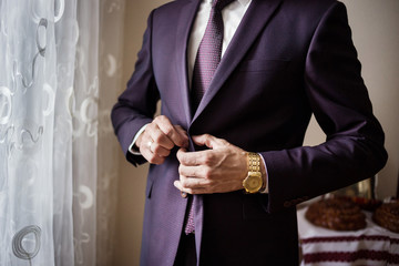 Businessman wears a jacket,male hands closeup,groom getting ready in the morning before wedding ceremony