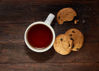 Cup of tea with meringues on a wooden background, top view