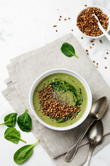 Useful smoothies from spinach with buckwheat flakes in ceramic bowls on gray concrete table background. Selective focus. Top view. Copy space.