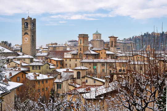 Fototapeta View of cityscape with bell tower during winter