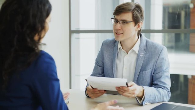 HR male manager shaking hand to female candidate after having job interview in modern office