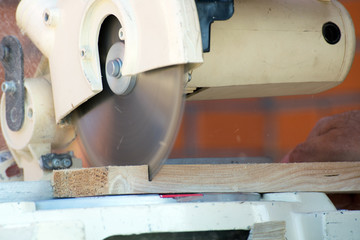 Close-up of carpenter cutting a wooden plank