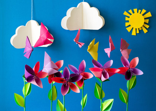 Origami paper flowers, butterflies, clouds and sun. Paper art craft