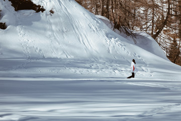 Woman hiking on the snow - into the wild