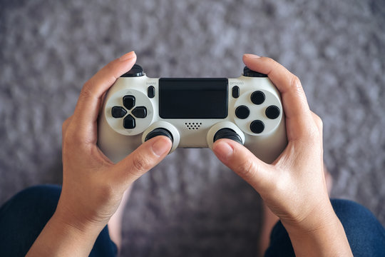 Top view image of hands holding the game controller while playing games
