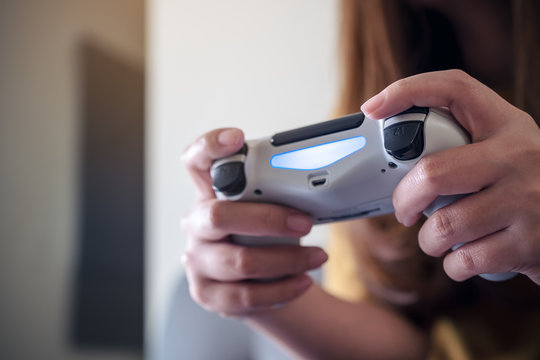 Closeup image of hands holding the game controller while playing games