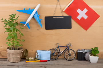 Travel time - blank blackboard, flag of the Switzerland, airplane model, camera, bicycle