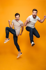 Portrait of a two cheerful young men jumping