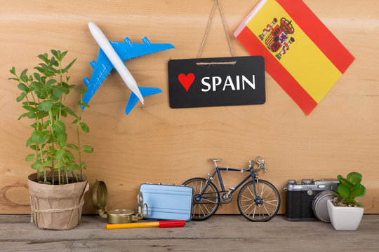 Travel time - blackboard with text "Love Spain", flag of the Spain, airplane model, camera, bicycle
