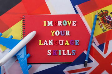 Learning languages concept - notepad and colorful wooden letters with text 