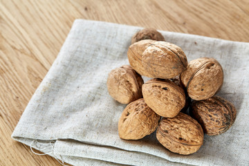 A stack of walnuts piled together and on rustic wooden background, shallow depth of field, selective focus