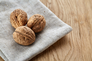 A stack of walnuts piled together and on rustic wooden background, shallow depth of field, selective focus