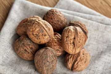 A stack of walnuts piled together and on rustic wooden background, shallow depth of field, selective focus