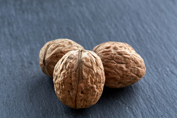 A stack of walnuts piled together and isolated on dark background, shallow depth of field, selective focus