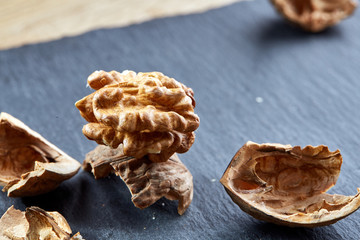 Top view close-up shot of cracked walnuts on dark background, shallow depth of field, macro