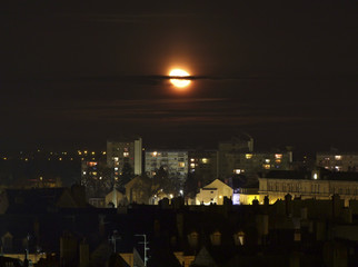 Fototapeta na wymiar Lune qui éclaire une ville la nuit.