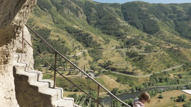 Young girl walks the stairs in cave monastery Vardzia - Georgia
