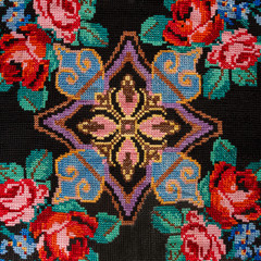 Fototapeta premium Embroidery hand made cross-stitch pattern in ethnic style on a black background fashion trend 2018
