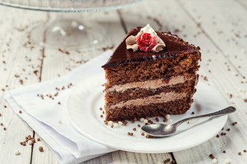 Dark chocolate vegan cake with cherries on wooden background