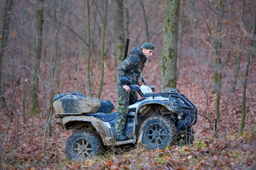 Hunter on ATV in the forest © Xalanx