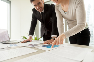 Woman pointing on variation of blue color on pantone swatch when choosing paint tone for apartment walls with designer or architect. Female real estate owner planning color concept of interior design