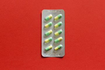 Drug blister package on red paper background