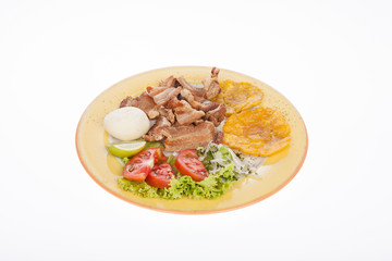 Colombian food, fried chicharron accompanied by salad, patacon and arepa