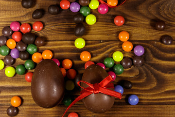 Easter composition with chocolate eggs on wooden background