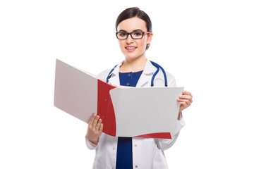 Young woman doctor with stethoscope holding binder in her hands in white uniform on white background