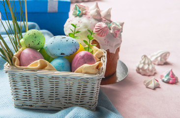 Close up basket with colored eggs locating near delicious easter cake. Kulich concept