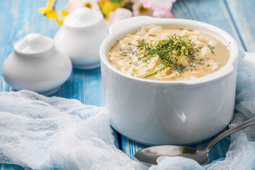Tasty mushroom soup with noodles on a wooden table.